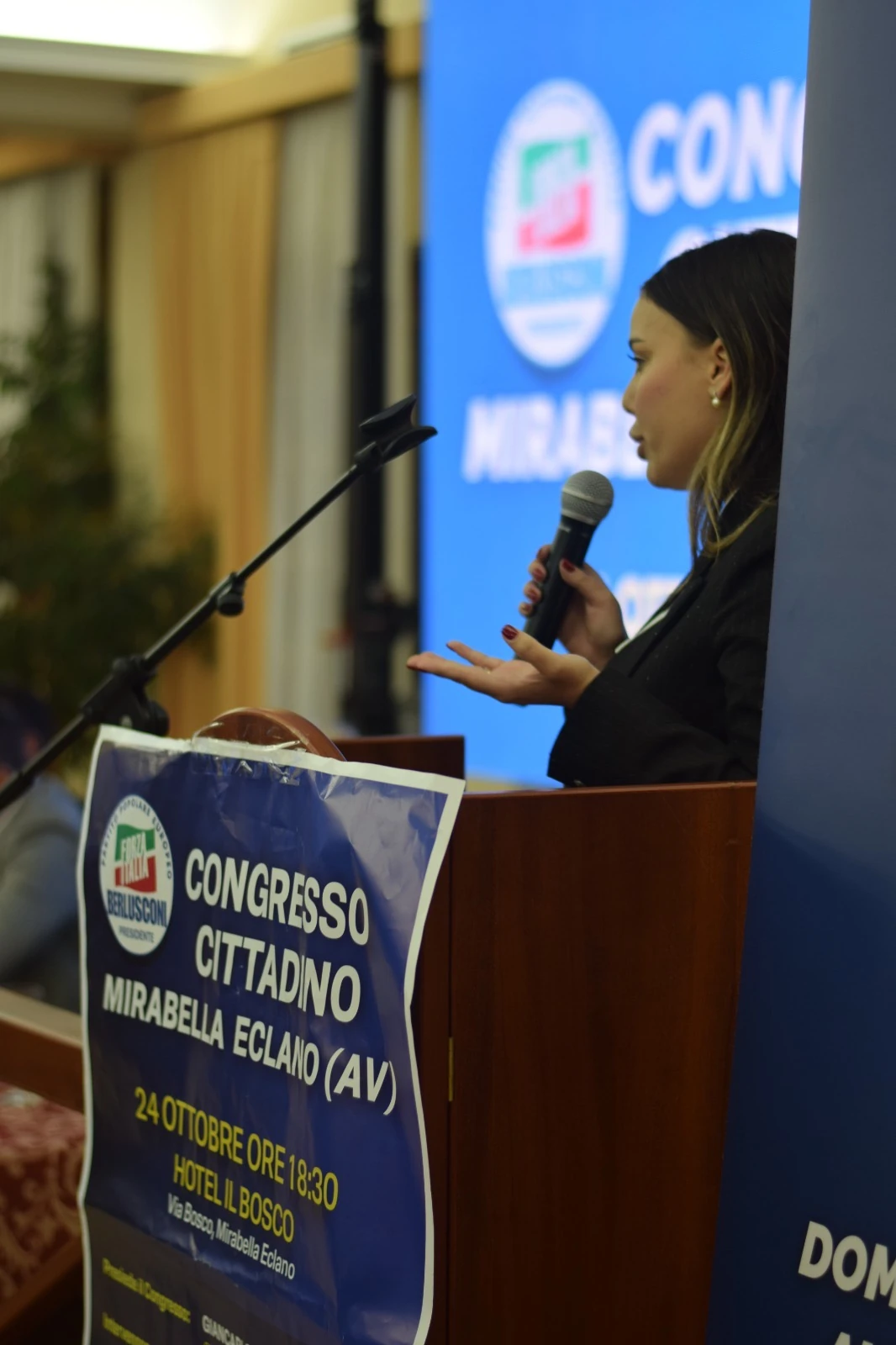 Un intervento al microfono, accanto al manifesto del congresso di Mirabella Eclano.