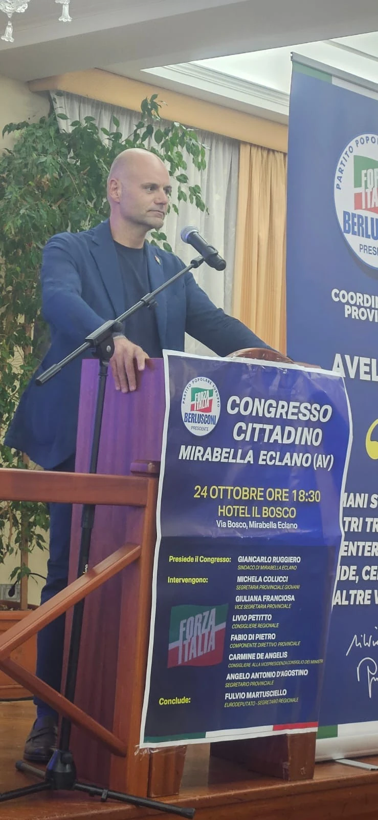 Un intervento dal podio accanto al manifesto del congresso di Mirabella Eclano.