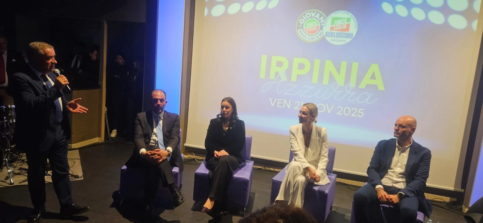 Relatori sul palco e un intervento al microfono durante un evento. Archivio fotografico Regionali 2025.