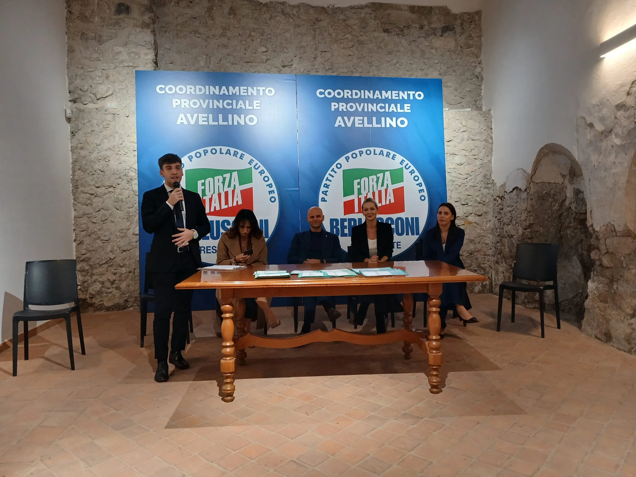 Il tavolo dei relatori in una sala con i pannelli del coordinamento provinciale di Avellino. Archivio fotografico Regionali 2025.