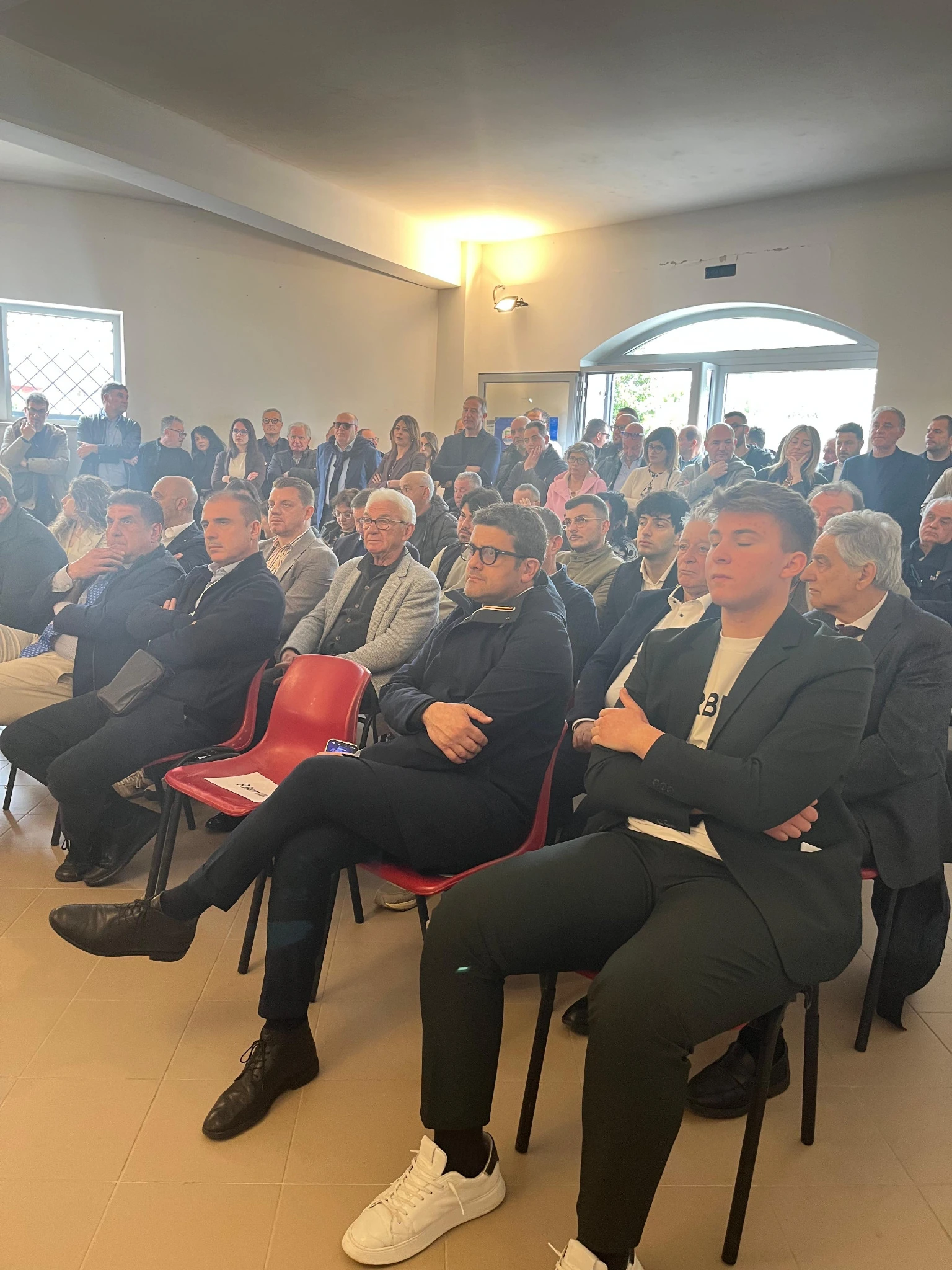 Partecipanti seduti e in piedi nella sala del congresso di Venticano