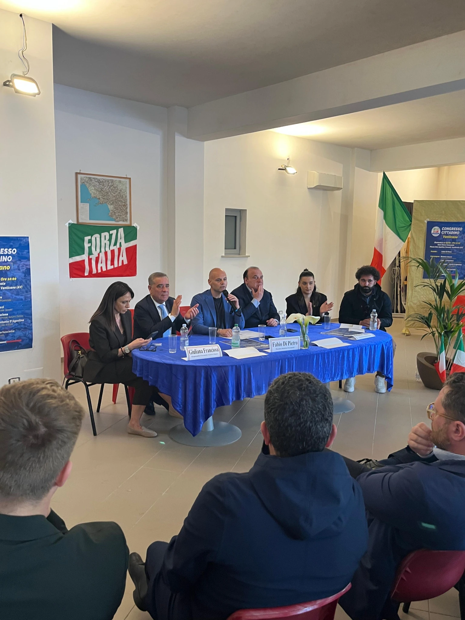 Il tavolo congressuale durante un intervento al microfono e un applauso